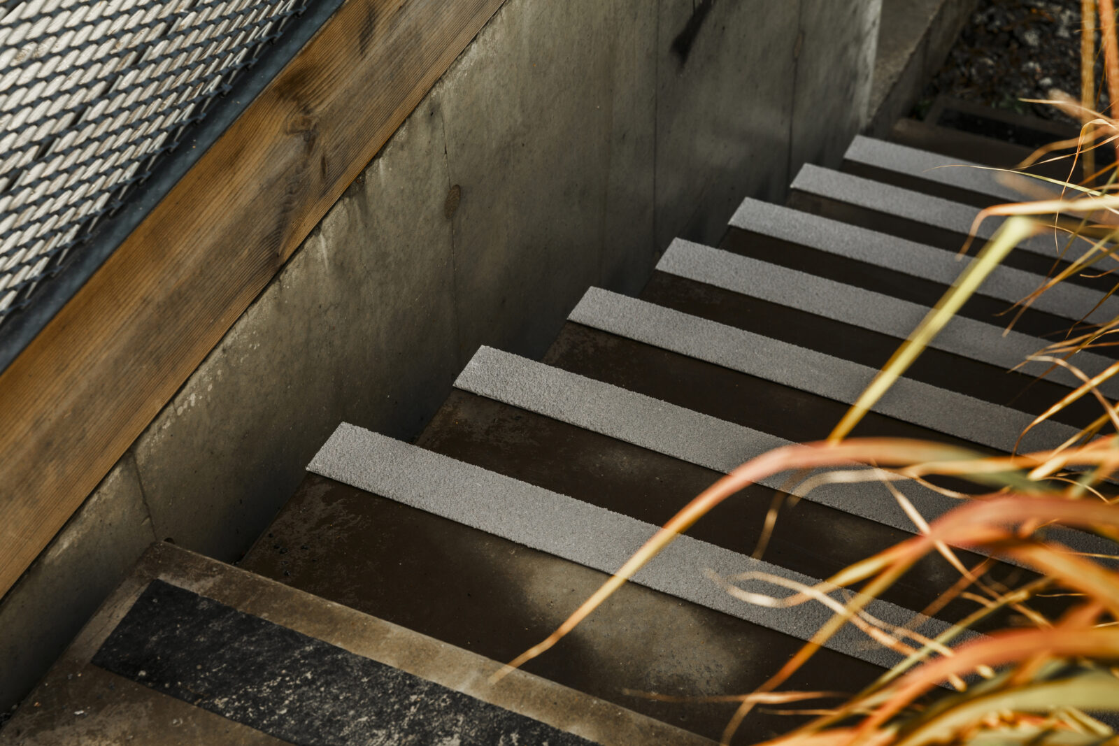 Gråa trappnoslister på blöt stentrappa