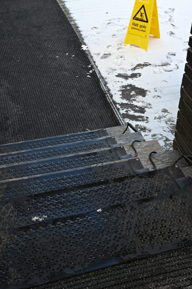 Svarta värmemattor på trappa i betong. Seriekopplade snösmältningsmattor.