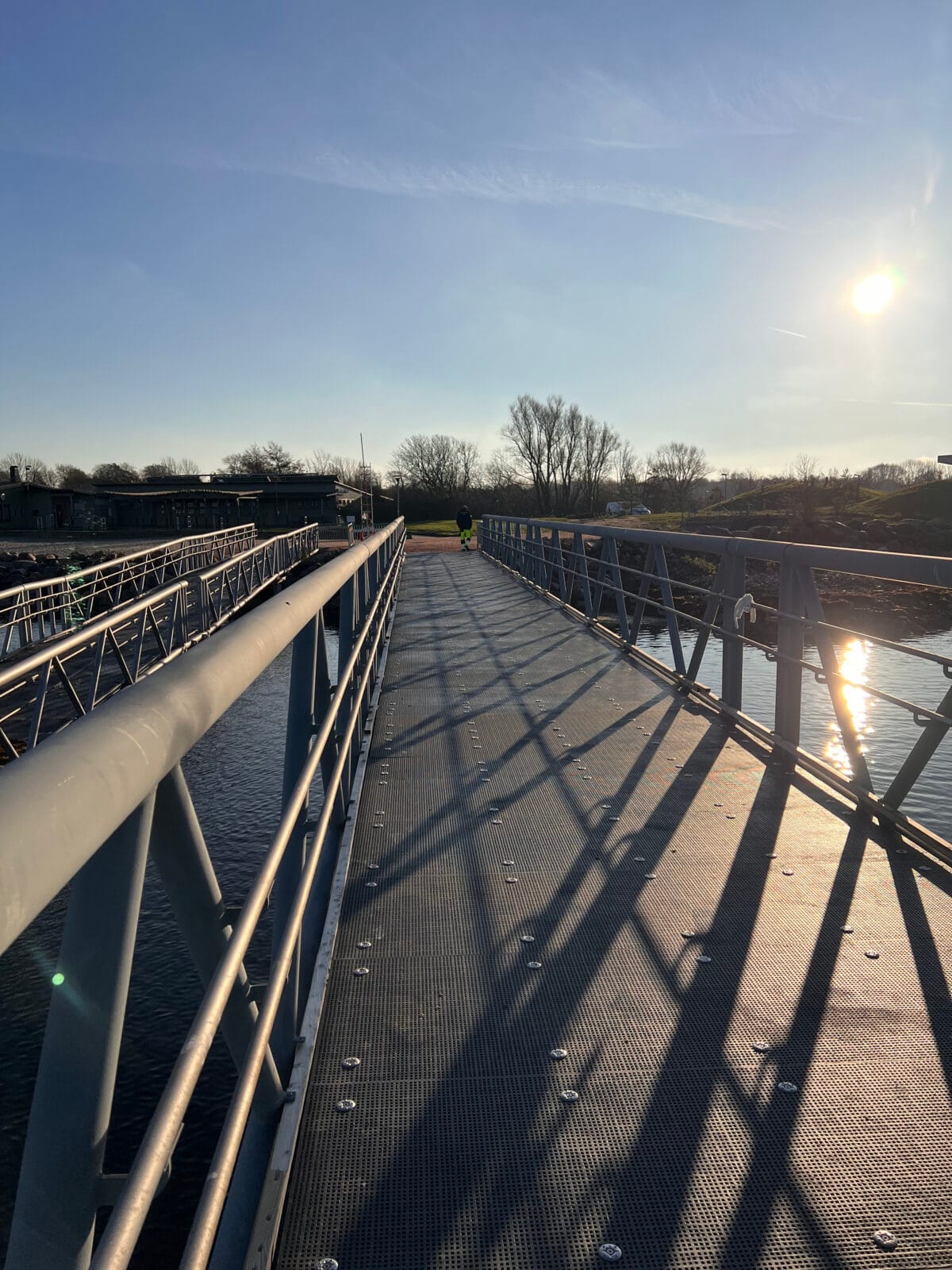 Brygga i grå, finmaskig glasfiberdurk leder ut i havet